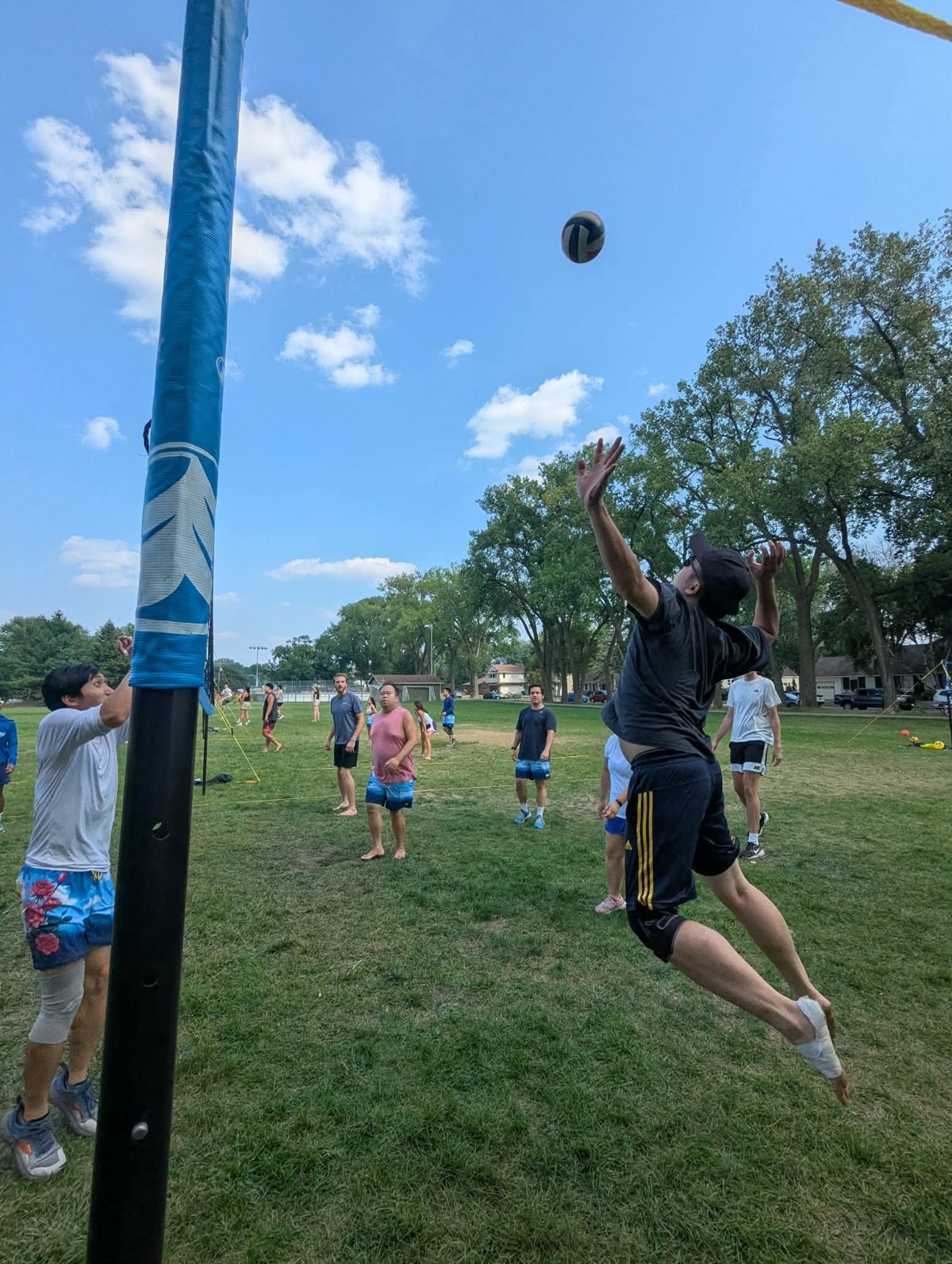 A player jumps for the ball during outdoor volleyball at the Swing on One + potluck